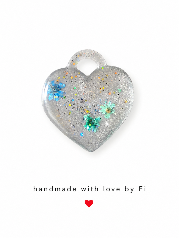 Holographic silver glitter resin heart pendant with blue and teal sequin flower embeds handmade by Fi