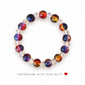 Handmade galaxy crackle glass bracelet with red, orange, blue and purple beads and clear crystal spacers