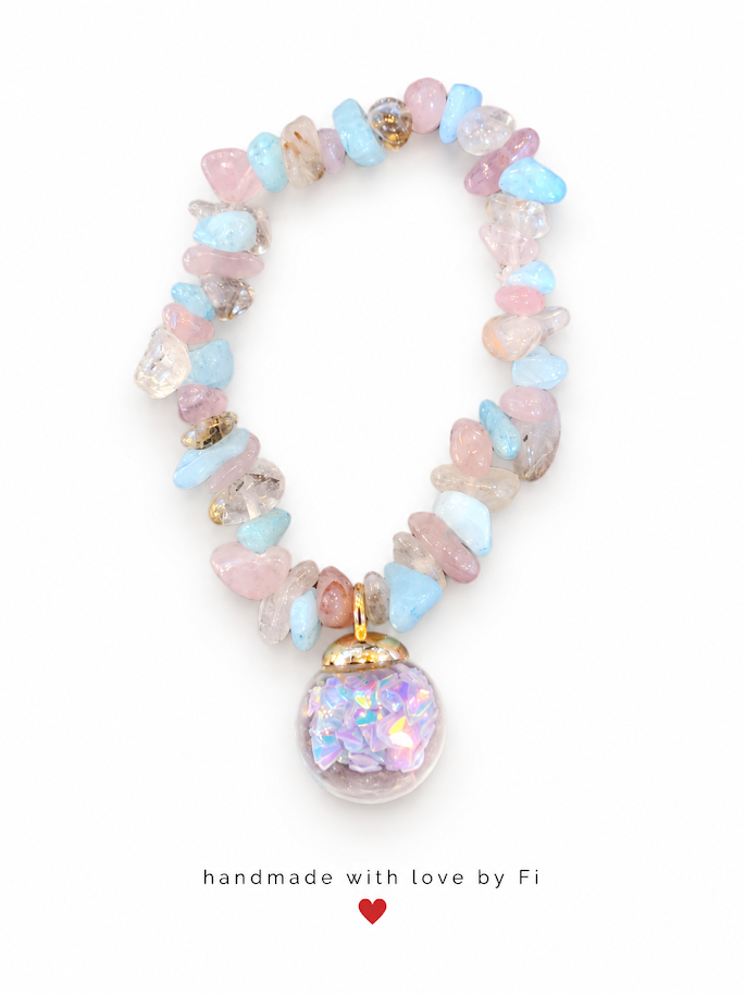 Pastel pink and blue gemstone chip bracelet with gold-tone accents and sparkling charm