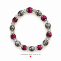 Handmade bracelet with magenta and shimmering charcoal-grey beads, silver-tone floral caps and clear accents