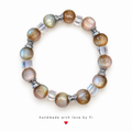 Neutral-toned beaded bracelet with clear cube beads and silver-tone bow spacers