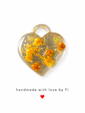 Yellow and orange dried botanical resin heart pendant with chunky gold hexagon glitter sequins handmade by Fi