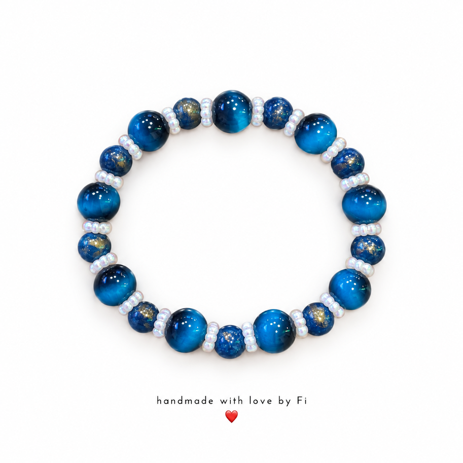 Handmade deep blue bracelet with golden galaxy-effect beads and small pearl-look spacers