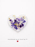 Clear resin heart pendant filled with purple amethyst chips, dried flower, holographic glitter and gold sequins handmade by Fi